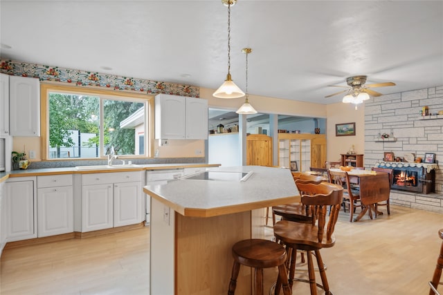 707 W Desta St, Hamilton, MT 59840 - kitchen featuring white cabinets, hanging light fixtures, a stone fireplace, and ceiling fan