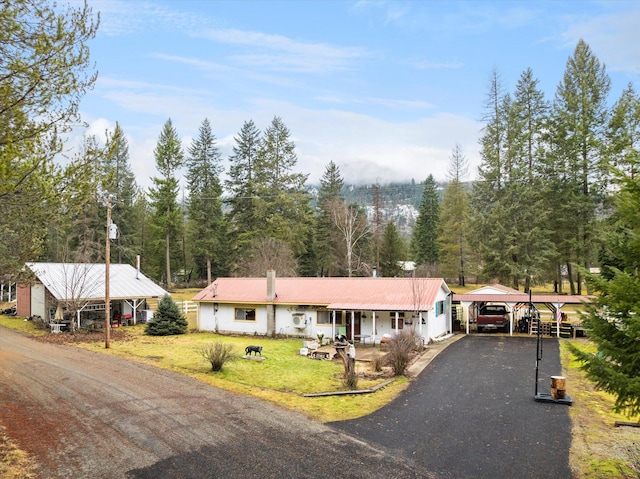 view of front facade with a carport, a porch, and a front lawn