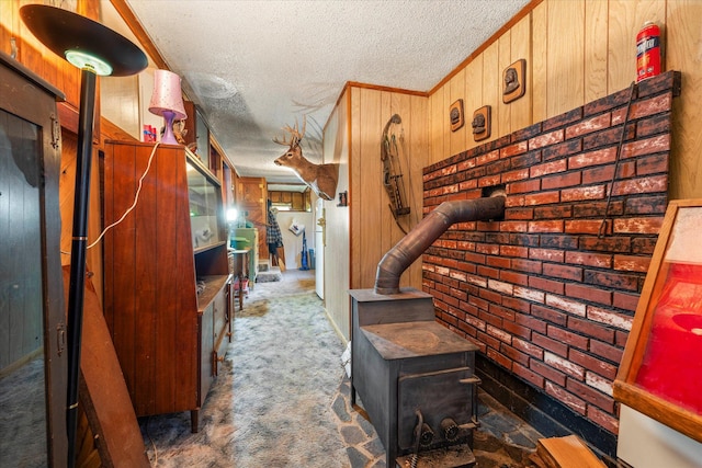 hall with carpet flooring, a textured ceiling, and wooden walls