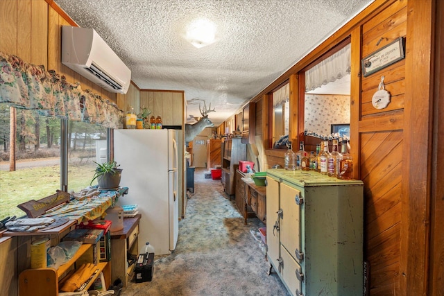 kitchen featuring a wall mounted air conditioner, white refrigerator, wood walls, and carpet floors