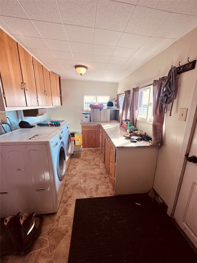 laundry room with light tile floors, cabinets, separate washer and dryer, and a healthy amount of sunlight