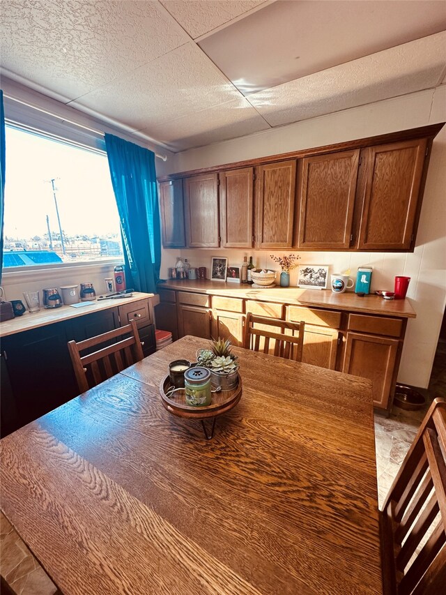 kitchen featuring a drop ceiling and light tile floors