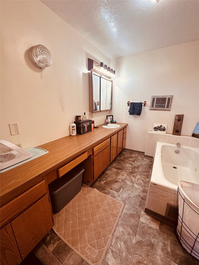 bathroom featuring tile flooring, tiled tub, and a textured ceiling