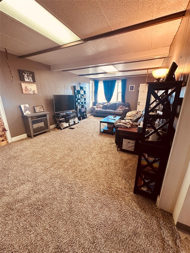 living room featuring a paneled ceiling and dark carpet