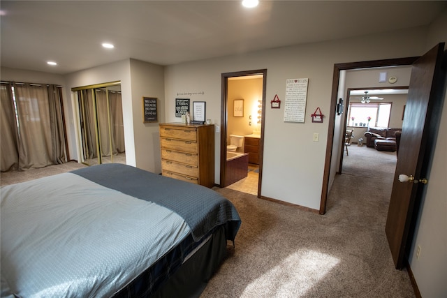 bedroom featuring a closet, connected bathroom, and light colored carpet