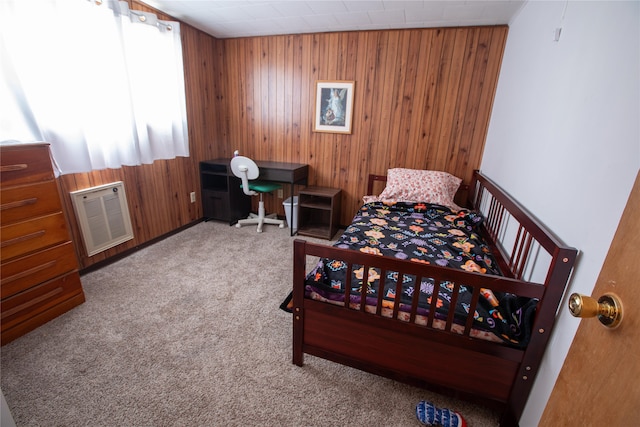 bedroom with wooden walls, light colored carpet, and lofted ceiling