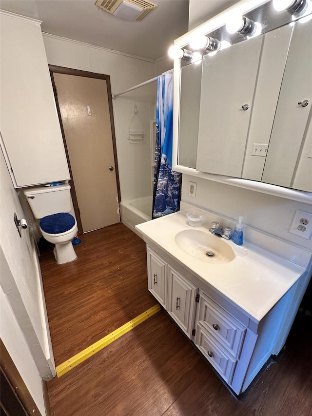 full bathroom featuring shower / bath combination with curtain, toilet, vanity, hardwood / wood-style flooring, and crown molding