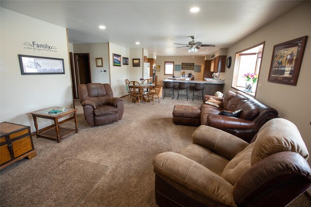 living room with ceiling fan and light colored carpet