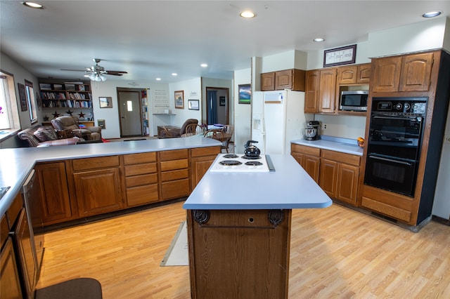 kitchen featuring ceiling fan, appliances with stainless steel finishes, a center island, and light hardwood / wood-style floors