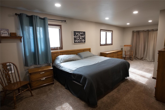 bedroom with dark colored carpet and multiple windows