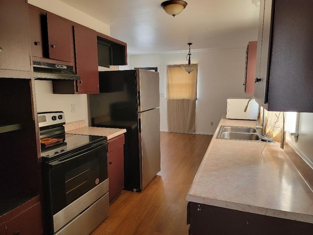 kitchen with stainless steel appliances, ventilation hood, sink, light hardwood / wood-style floors, and pendant lighting