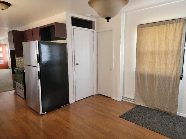 kitchen with light wood-type flooring, dark brown cabinetry, and stainless steel appliances