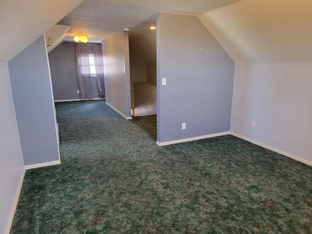 bonus room with lofted ceiling and dark carpet