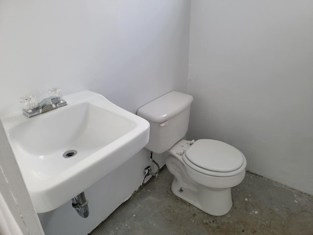 bathroom featuring concrete floors, sink, and toilet