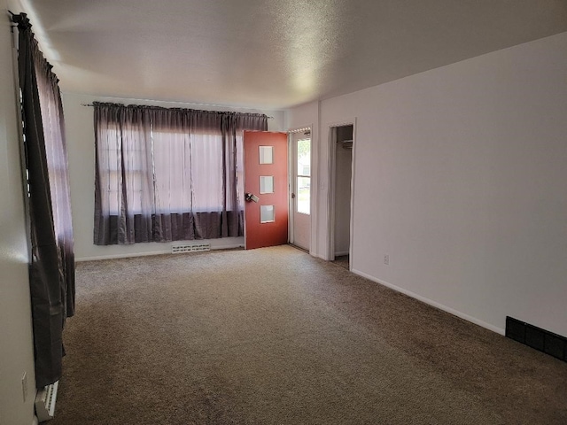 empty room with carpet and a textured ceiling