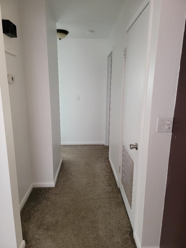 hall with dark colored carpet