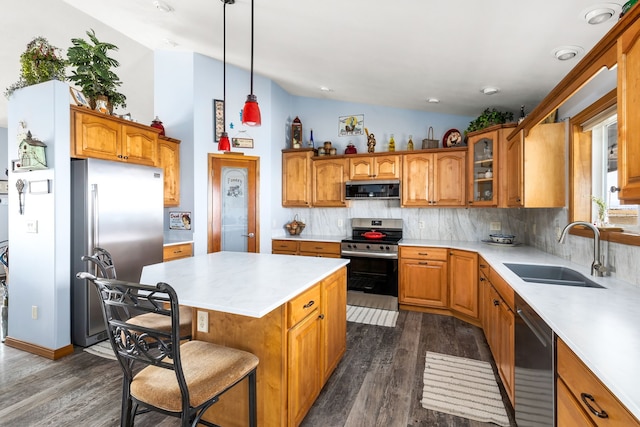 kitchen with sink, hanging light fixtures, stainless steel appliances, backsplash, and a kitchen island