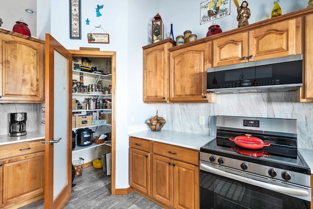 kitchen with appliances with stainless steel finishes, tasteful backsplash, and light hardwood / wood-style flooring