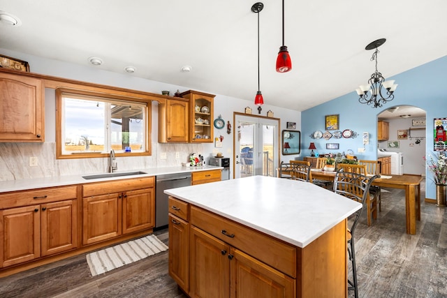 kitchen with tasteful backsplash, dishwasher, sink, and lofted ceiling