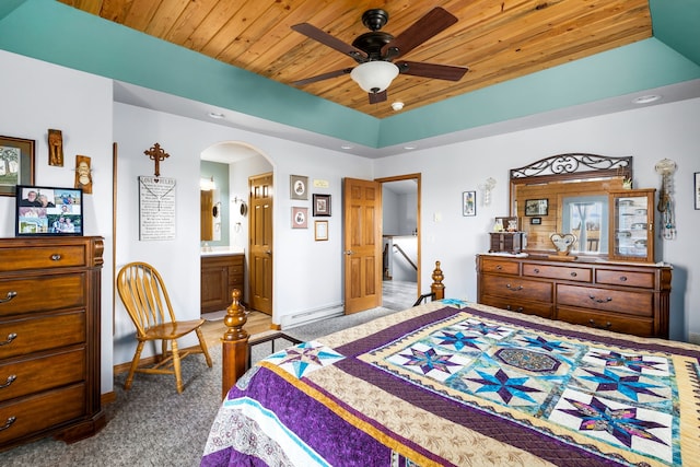 bedroom featuring connected bathroom, ceiling fan, carpet floors, a tray ceiling, and wood ceiling