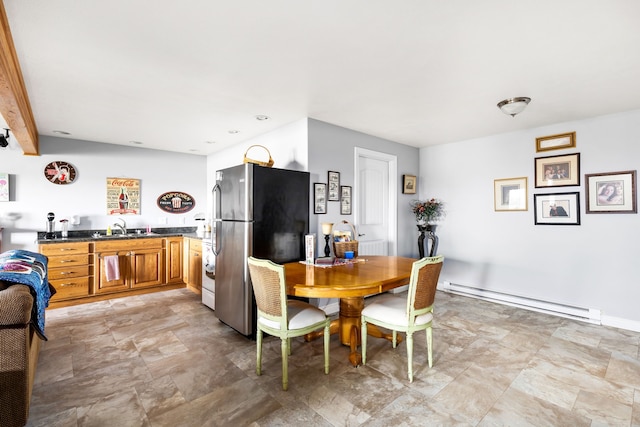 dining space with a baseboard heating unit and sink