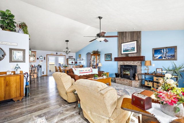 living room featuring lofted ceiling, ceiling fan with notable chandelier, and hardwood / wood-style flooring