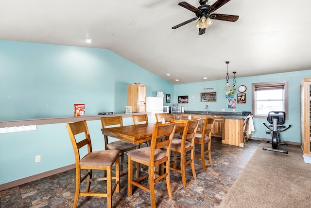 dining area with bar area, ceiling fan, and vaulted ceiling