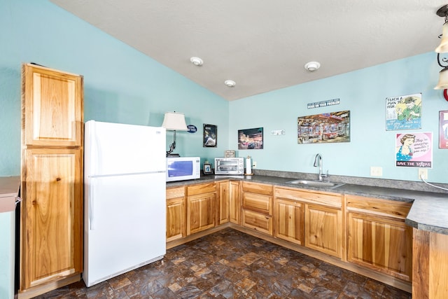 kitchen featuring white appliances, lofted ceiling, and sink