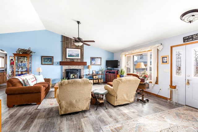 living room with hardwood / wood-style floors, ceiling fan, a tile fireplace, and vaulted ceiling