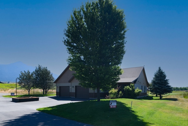 30 Demers Pl, Eureka, MT 59917 - view of front of home featuring a garage, a front yard, and a mountain view