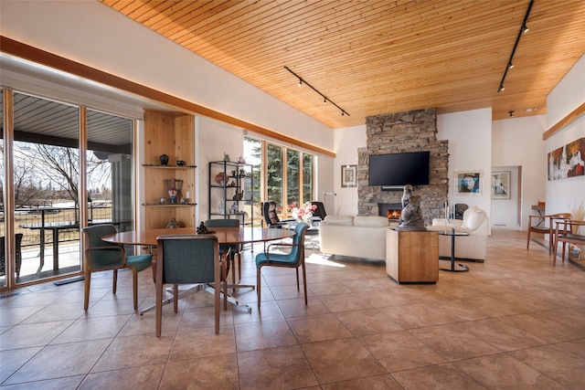 tiled dining room featuring wooden ceiling, a fireplace, and rail lighting