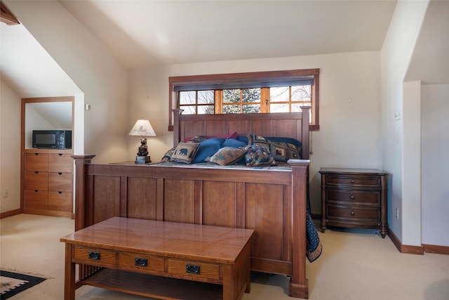 bedroom with lofted ceiling and light colored carpet