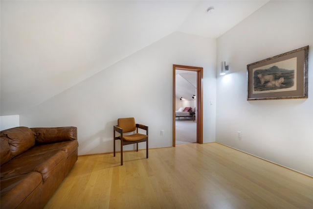 living room with light hardwood / wood-style floors and vaulted ceiling