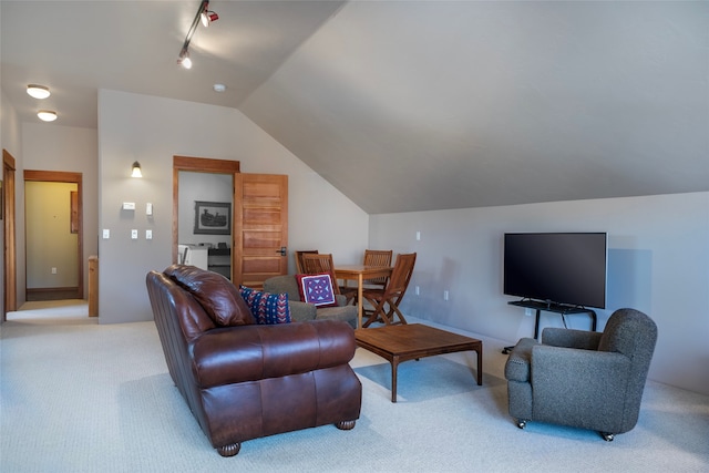 living room with track lighting, vaulted ceiling, and light carpet