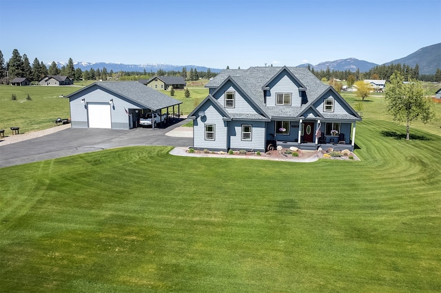 view of front of house featuring a mountain view, an outdoor structure, a garage, a front lawn, and covered porch