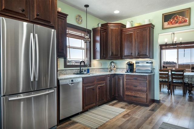 165 Jewel View Dr, Columbia Falls, MT 59912 - kitchen featuring appliances with stainless steel finishes, healthy amount of natural light, dark brown cabinetry, and a chandelier