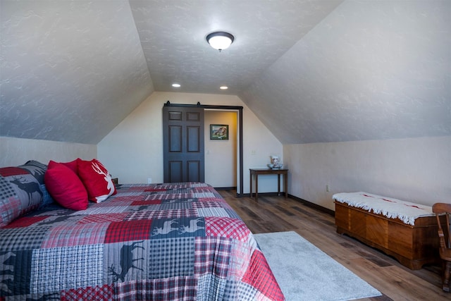 165 Jewel View Dr, Columbia Falls, MT 59912 - bedroom with wood finished floors, vaulted ceiling, and a textured ceiling