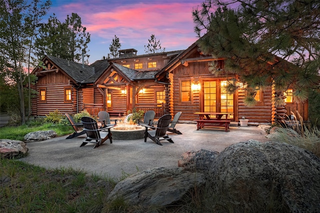 back house at dusk featuring an outdoor fire pit and a patio area