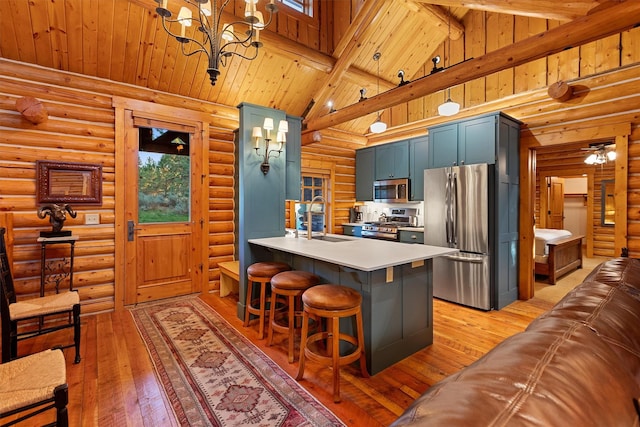 770 Pallo Trl, Hamilton, MT 59840 - kitchen with appliances with stainless steel finishes, blue cabinetry, rustic walls, light wood-type flooring, and light countertops