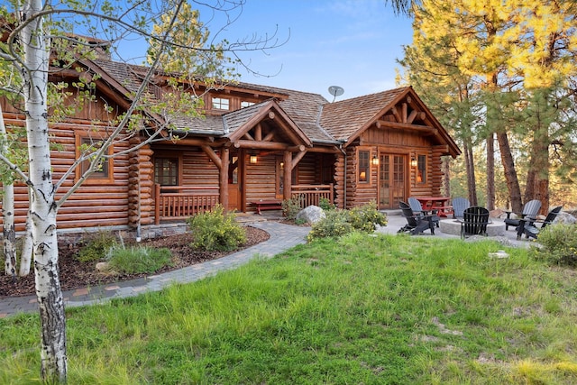 770 Pallo Trl, Hamilton, MT 59840 - log cabin with log siding, an outdoor fire pit, covered porch, and a chimney