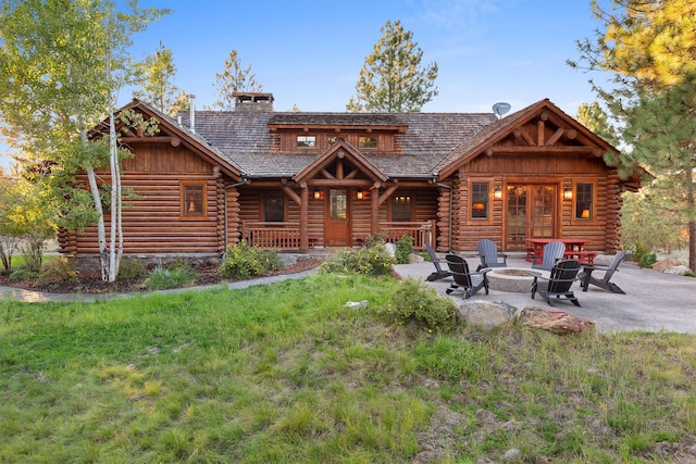 view of front of home featuring an outdoor fire pit, a front lawn, and a patio