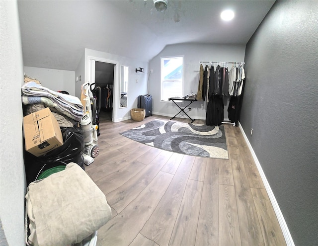 workout room featuring lofted ceiling and light hardwood / wood-style flooring