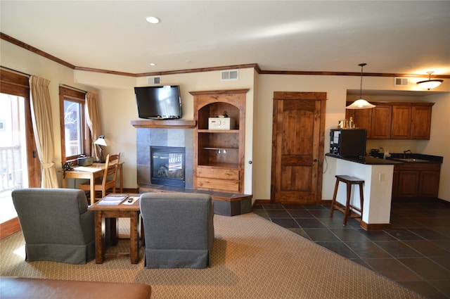 tiled living room with a tiled fireplace and sink