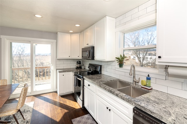 kitchen featuring white cabinets, backsplash, black appliances, and light stone counters