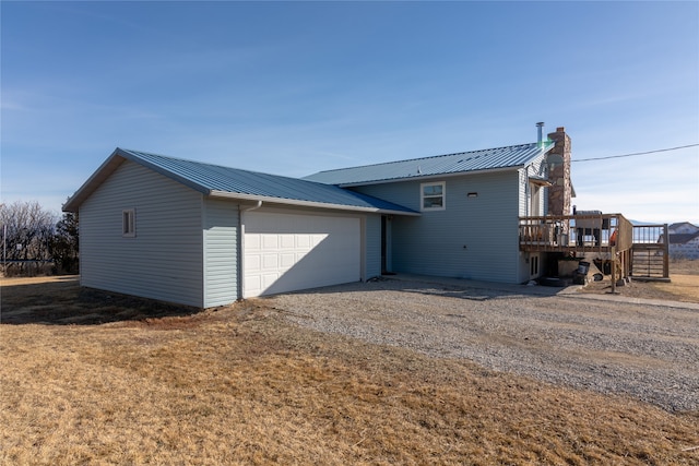 rear view of house featuring a deck and a garage