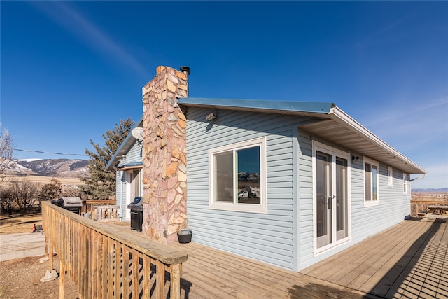 view of side of home featuring a deck with mountain view