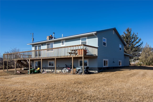 back of property with a deck and a yard