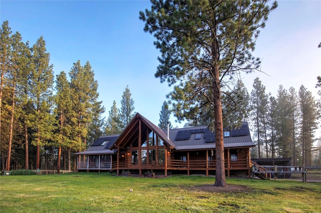 rear view of house with a yard and solar panels