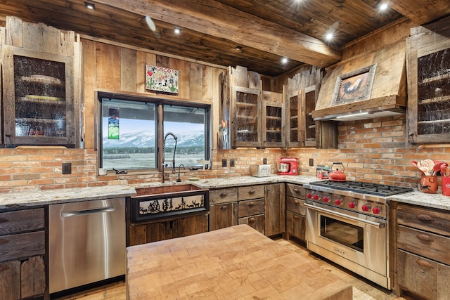 kitchen with appliances with stainless steel finishes, dark brown cabinets, light wood-type flooring, and light stone countertops