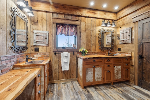 bathroom featuring wooden walls, wood-type flooring, and vanity